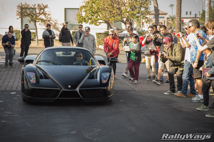 Lots of of car show attendees hound this black Ferrari Enzo